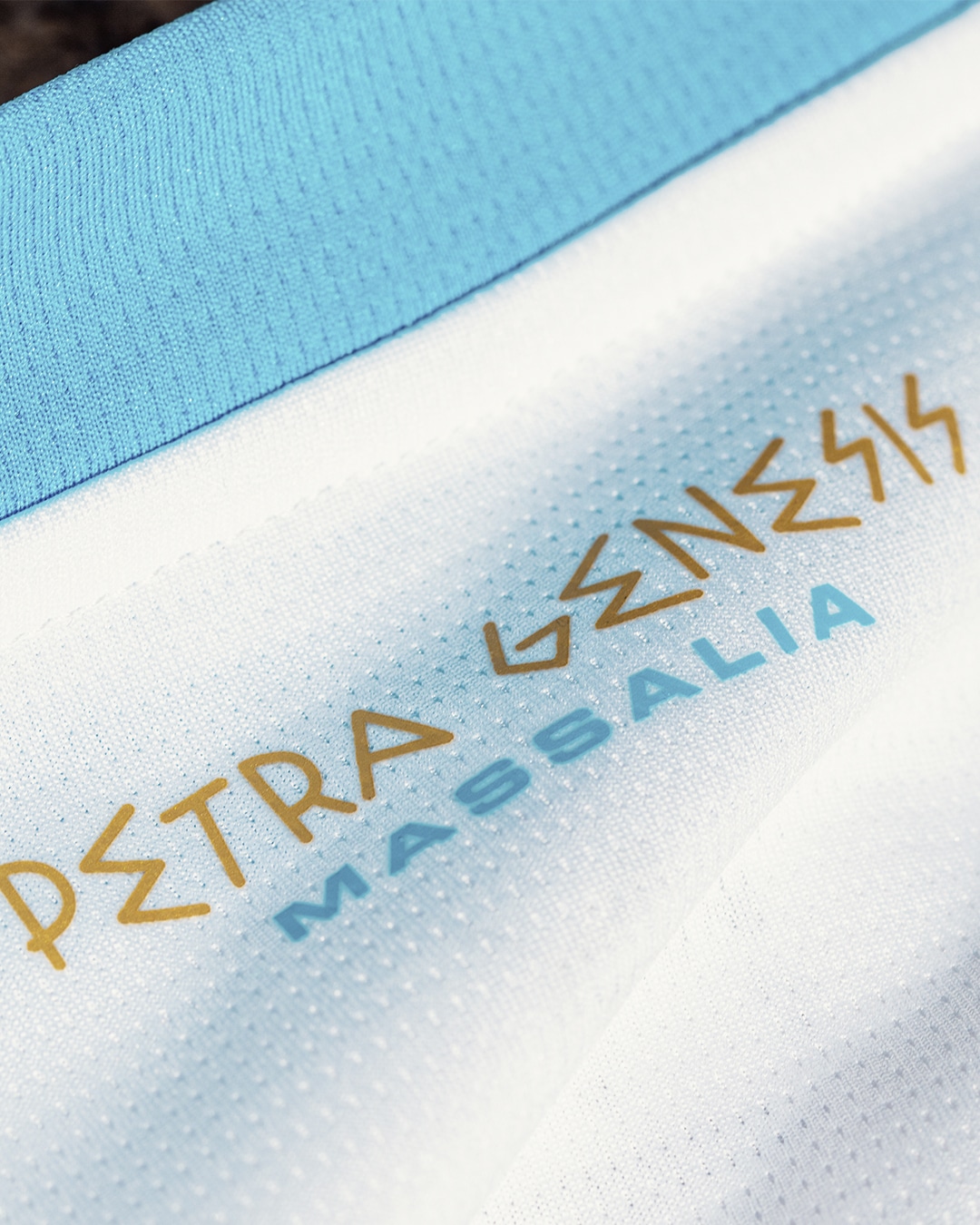 Inscription Petra Genesis sur le col du maillot domicile OM 2023 2024 Evoquant la premiere pierre